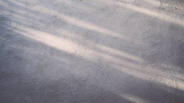 Çatı katı tarzında beton cilası duvar. Duvarında güneş ışığı var. Soyut boş gri beton oda iç arka planı. Cilalı beton yüzeyi olan gri beton duvarın yüzeyindeki güneş ışığı