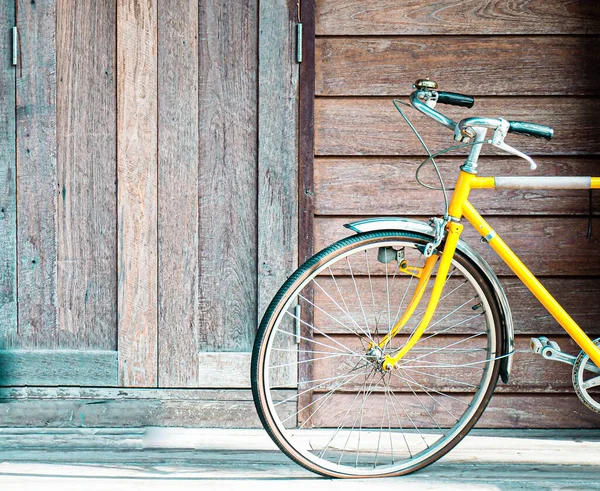 古い木製の壁の背景にヴィンテージ黄色の自転車 ライフスタイルの考え方 — ストック写真