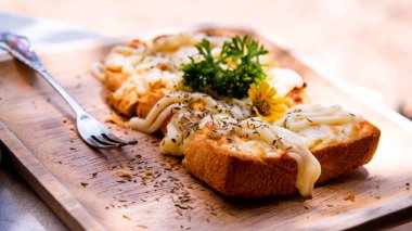 Dilimlenmiş beyaz ekmek üzerine mayonez serpiştirilmiş çiçek ve sebzeyle süslenmiş..