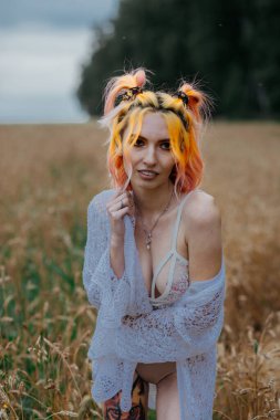 Buğday tarlasında iç çamaşırlı, siyah saçlı bir kız.