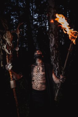 Ormanda vücudunda işaretler olan bir büyücü.