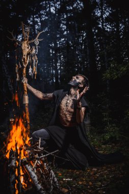 Ormanda vücudunda işaretler olan bir büyücü.
