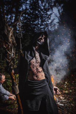 Ormanda vücudunda işaretler olan bir büyücü.