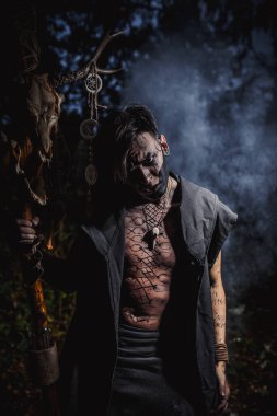 Ormanda vücudunda işaretler olan bir büyücü.