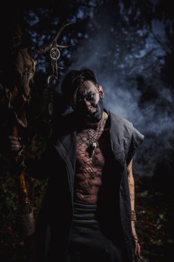 Ormanda vücudunda işaretler olan bir büyücü.