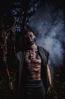 Ormanda vücudunda işaretler olan bir büyücü.