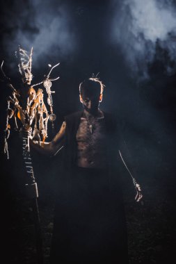 Ormanda vücudunda işaretler olan bir büyücü.