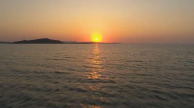 Doğal gün batımında deniz ufkunda güneşe uçan drone