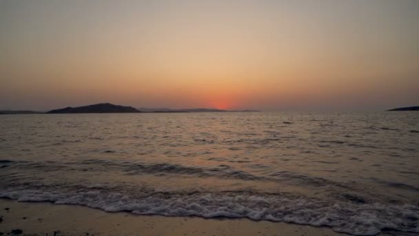 Olas tranquilas se estrellan en la playa de arena en Grecia — Vídeos de Stock