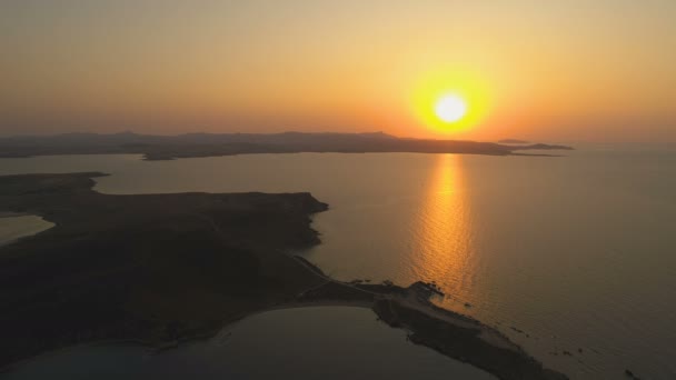 Μαγευτικό ηλιοβασίλεμα με τεράστιο πορτοκαλί ήλιο πάνω από την παράκτια γραμμή του νησιού — Αρχείο Βίντεο