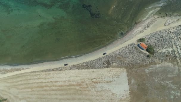 Aerial, drone widok samochodów jeżdżąc na przybrzeżnej drodze piaskowej w Lemnos, Grecja — Wideo stockowe