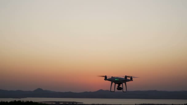 Közel látod lebeg quadcopter drone forgatás a naplemente táj — Stock videók