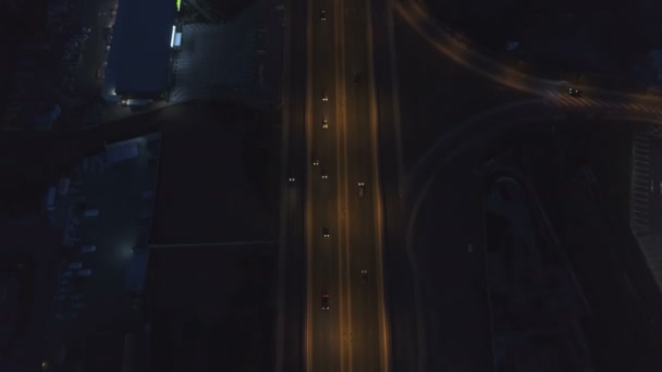 Weg kruising met rotonde en stadsverkeer in de nacht — Stockvideo