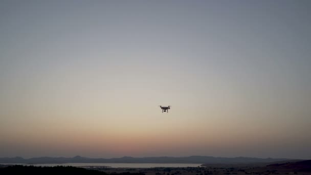 Drone quadcopter noir débarquant après avoir filmé la côte de la mer — Video