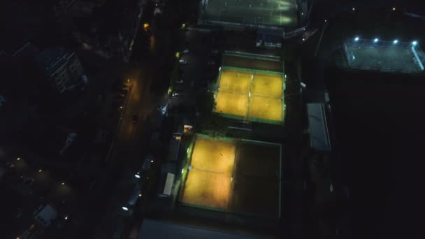 网球场和迷你足球场的鸟瞰图在夜间在运动场点亮 — 图库视频影像