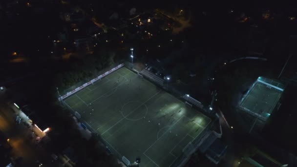 Vogelperspektive Luftaufnahme des Fußballfeldes während eines Spiels beleuchtet in der Nacht beim Sport — Stockvideo