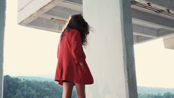 Hermosa mujer con chaqueta roja y vestido negro caminando alrededor — Vídeo de stock