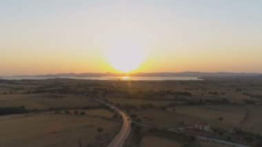 Deniz üzerinde gündoğumukarşı coutryside yolda sürüş araba havadan drone görünümü