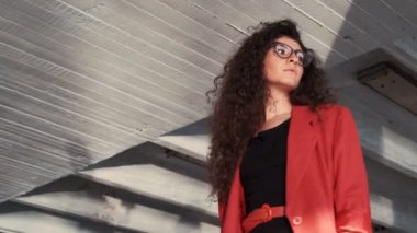 Sola bakan gözlük lü ve kırmızı ceketli zarif kadın model