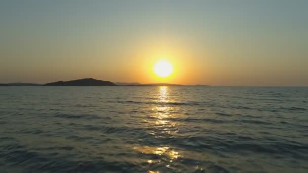 Vista aérea del dron de la superficie del mar con olas contra el amanecer naranja brillante — Vídeos de Stock