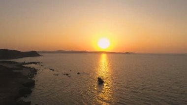 Yunanistan'da kayalık kıyıları yakınlarındaki sakin denizin üzerinde manzara Sundown havadan görünümü