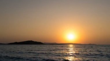 Parlak turuncu renkler ve deniz dalgaları ile deniz ufku üzerinde güzel gün batımı zaman atlama