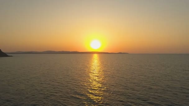 Золотой закат над островом со спокойным морем и ясным небом — стоковое видео