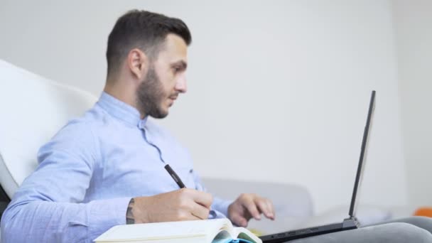 Joven hombre caucásico con barba trabajando con ordenador portátil en casa oficina — Vídeos de Stock