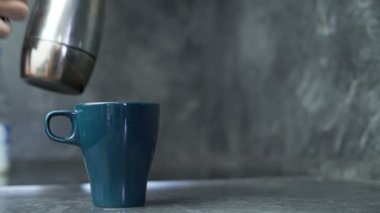 El dökme kahve koyu mavi kupa, süt takip ve bir kaşıkla karıştırma