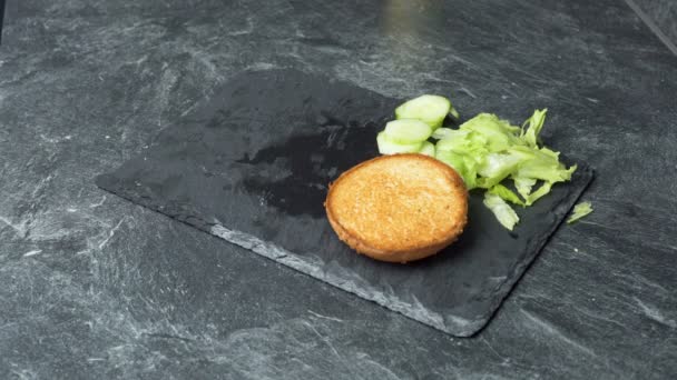Mannelijke chef-kok hand het regelen van ingrediënten om sandwich te bereiden op granieten kookplaat — Stockvideo