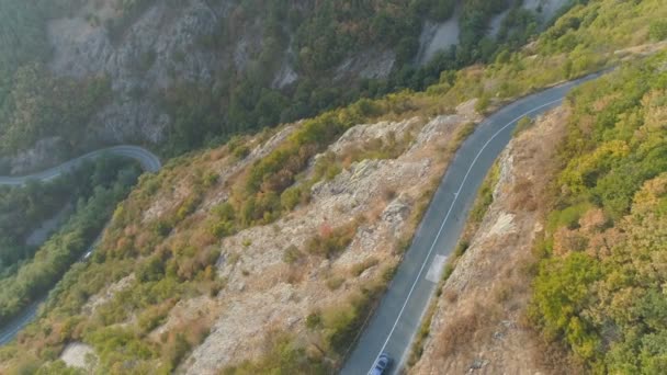 Drone po samochodach jazdy na ruchliwej skalistej górskiej drodze. Zajęty ruch na przełęczy w lecie — Wideo stockowe