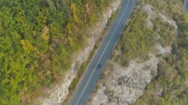 Havadan görünüm, drone dağ dolambaçlı yolda hızlı sürüş siyah araba kovalayan