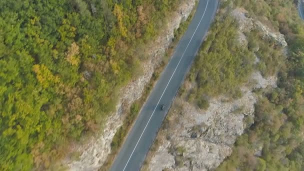 Luftbild: Drohne jagt schnell fahrendes schwarzes Auto auf kurvenreicher Straße — Stockvideo