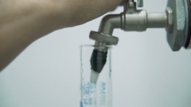 Bir laboratuvar dolgu ölçüm silindirinde farmasötik cbd yağı ile çalışan bilim adamı