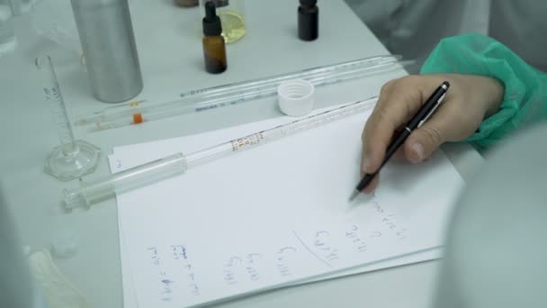 Wissenschaftler, der Forschungsergebnisse registriert und mit Stift auf weißem Papier im Labor korrigiert — Stockvideo