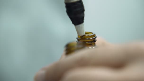 Olhada de perto dos cientistas mão enchimento conta-gotas garrafa com óleo CBD no laboratório — Vídeo de Stock