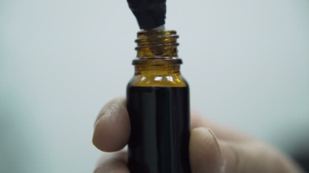 Små droppflaskor fylls med CBD olja från maskinen i hampa laboratorium inomhus — Stockvideo