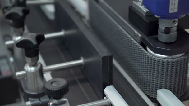 Zamknij wygląd maszyny do etykietowania butelek olejowych CBD w laboratorium konopi — Wideo stockowe