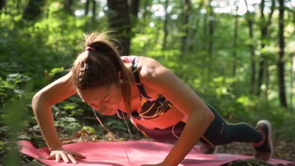 Närbild av fitness kvinna i sportkläder gör armhävningar och leende, utomhus träning — Stockvideo