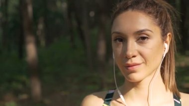 Kendinden emin, kahverengi gözlü, kameraya gülümseyen kız.