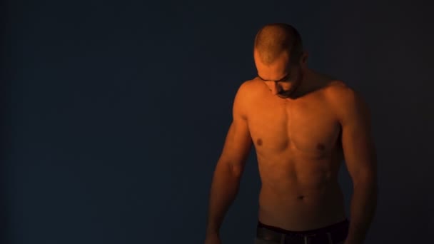 Modelo Fitness flexionando los músculos abdominales, mostrando abdominales aislados sobre fondo oscuro — Vídeo de stock