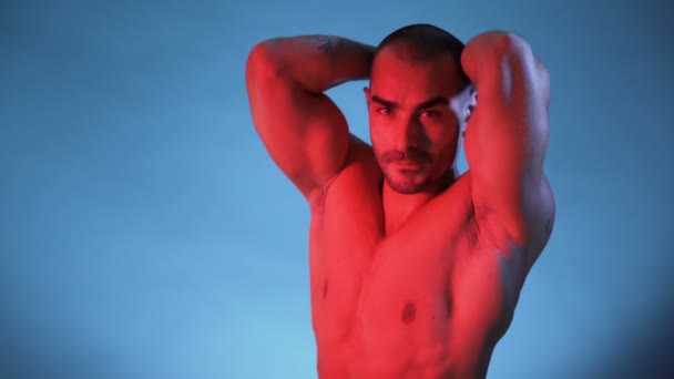 Мускулистый и сексуальный торс молодого человека, строитель на голубом фоне — стоковое видео