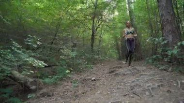 Spor kıyafetleri içinde koşan konsantre bayan atlet patikası.