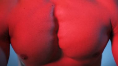 Kaslı bir adam, mükemmel karın kasları, tuzakları ve göğsü olan bir sporcu.