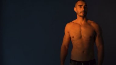 Çekici fitness modeli siyah arkaplana karşı harika bir vücut gösteriyor