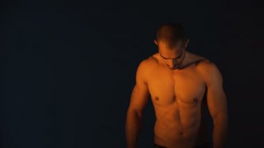 Siyah arka planda yakışıklı vücut geliştiricisinin stüdyo fotoğrafı.