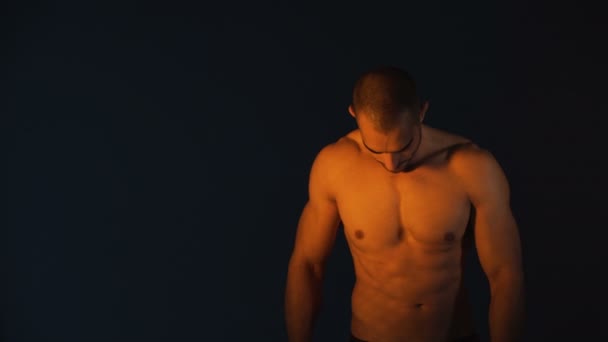 Studio shot van knappe bodybuilder tegen zwarte achtergrond — Stockvideo