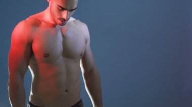 Mutlu, çekici, kaslı vücutlu, gülümseyen genç adamın portresi.