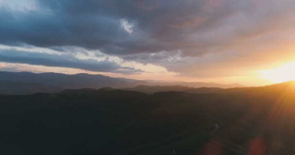 Rayons de soleil lumineux traversant le ciel, les nuages et la colline d'éclairage. Collines verdoyantes et prairies en montagne 