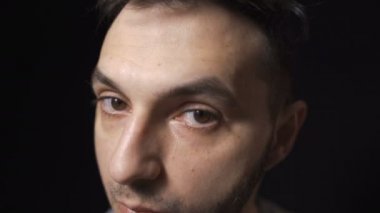Elektrikli tıraş makinesi ya da jiletle bıyık kesen adam, siyah arka planda izole edilmiş.